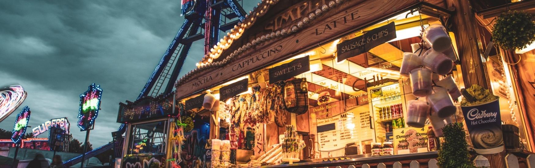 cosy looking fairground foodstall illuminates the night with a warm glow