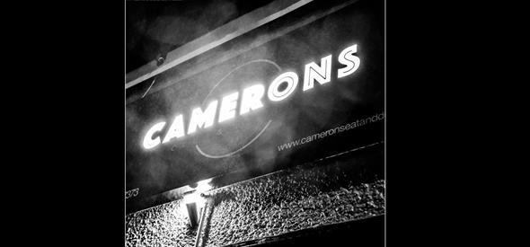 Camerons lit up sign in black and white.