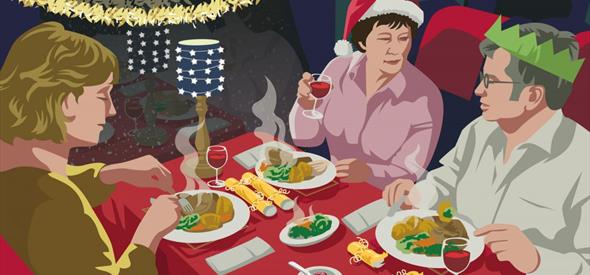 Family sitting around a table with food and Christmas decorations