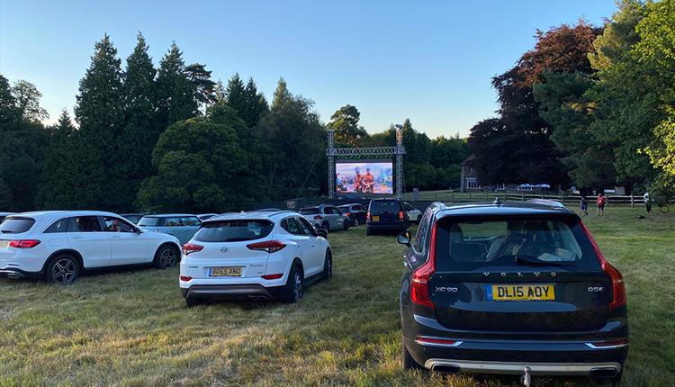 Row or cars outdoor watching a cinema screen
