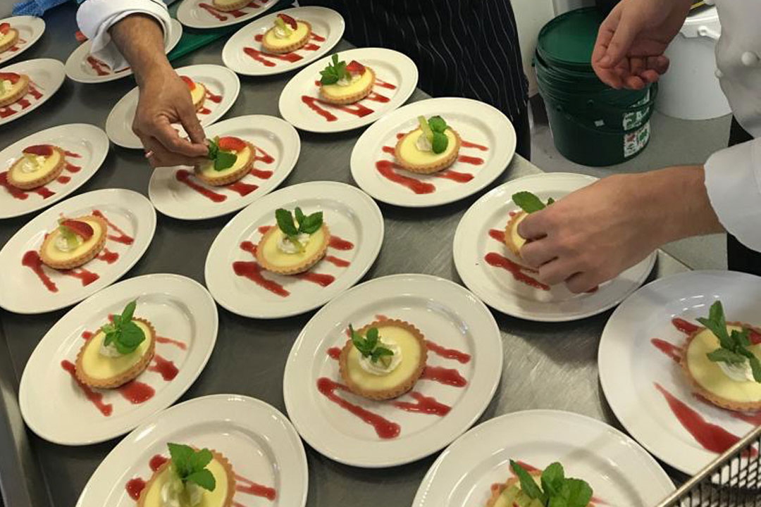 Two chefs preparing dessert food in the Kitchen 