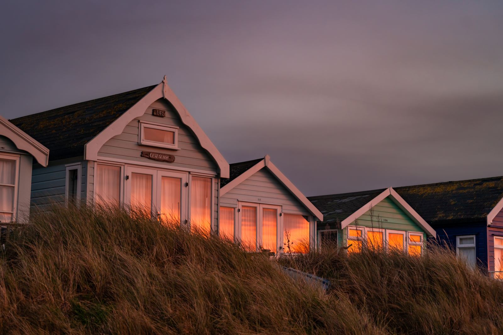 sunset reflecting on mudeford spit beach huts 