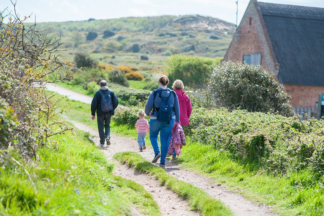 Family enjoying a walk at Hengistbury Head park on a beautiful day 