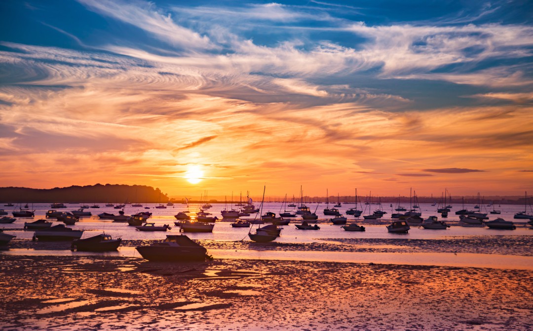 A view out toward Brownsea Island as the sun sets over Poole Harbour