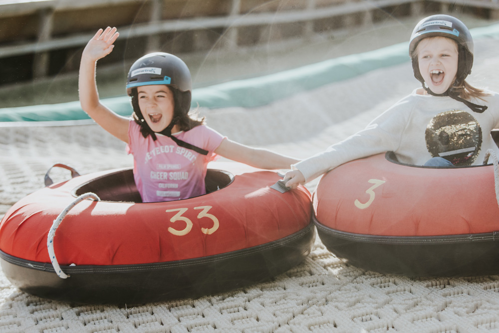 Two children laughing as they descend the Snowtrax ringo run near Bournemouth