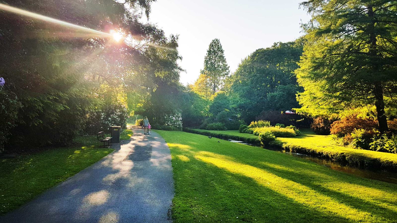 Mother and child enjoy a walk surrounded by tree's in Bournemouth Gardens 