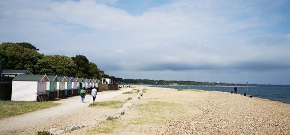 Wide shot of people walking on the dusty promenade at Avon Beach.