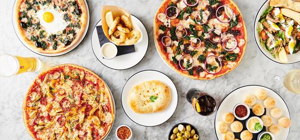 table of pizza and drinks laid out.