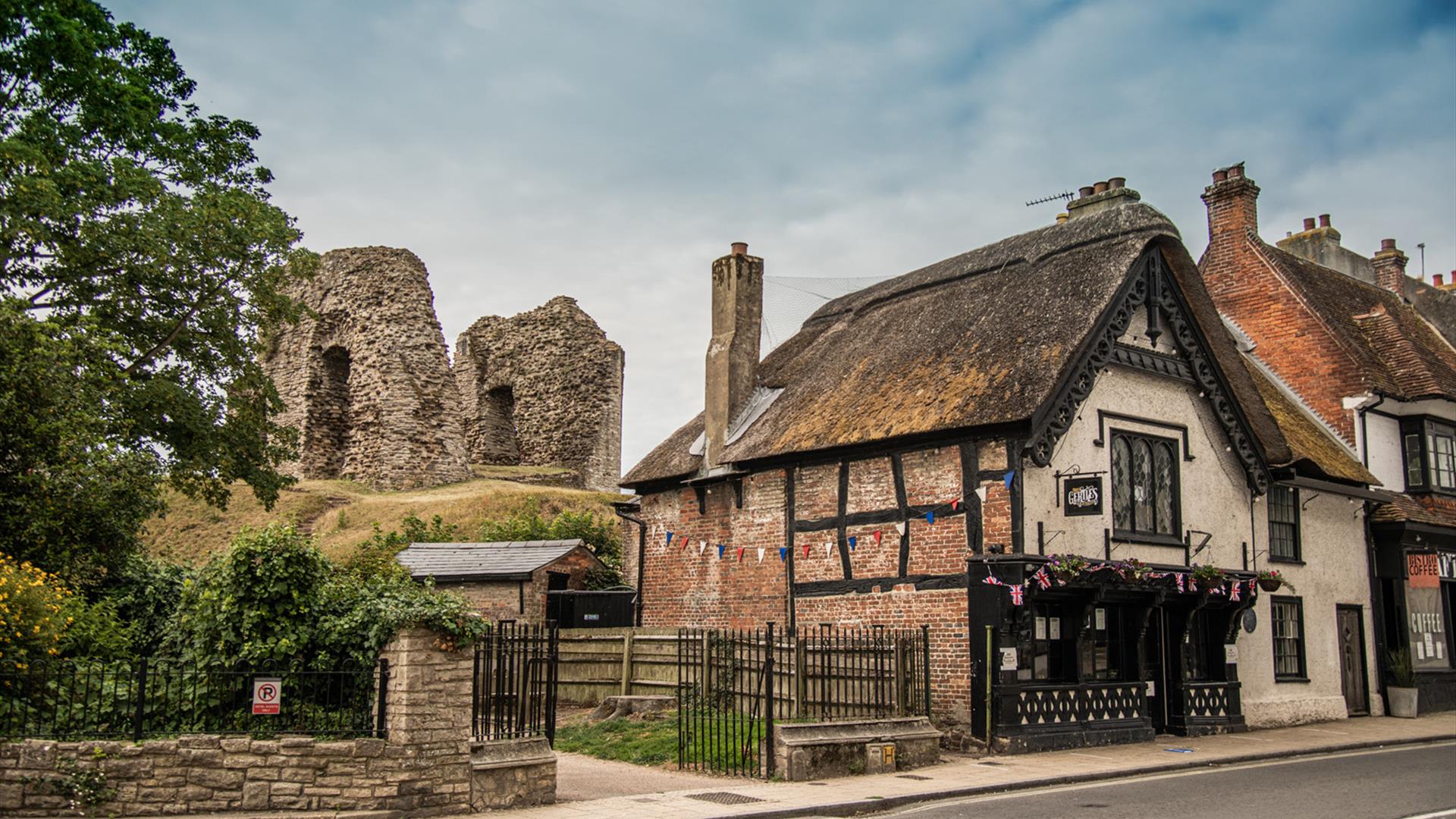 Historic cottage with old ruins on a hill in the background