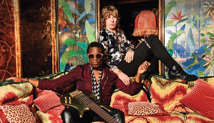 Brand New Heavies sitting on a sofa