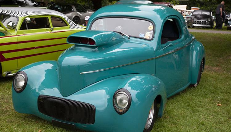 blue hot rod car parked on grass