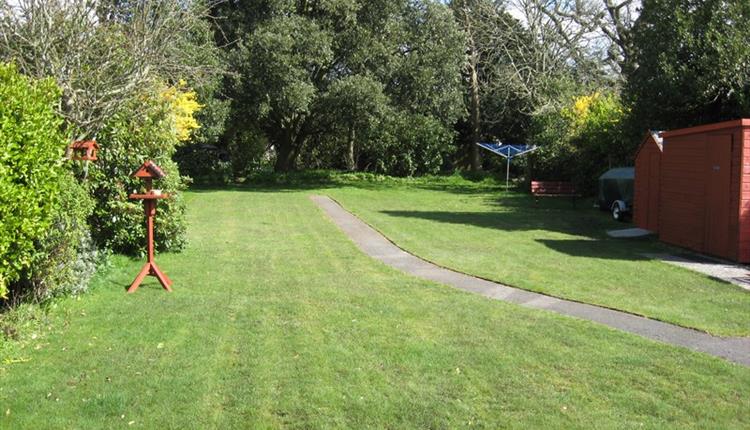 Garden with green grass and trees surrounding the garden