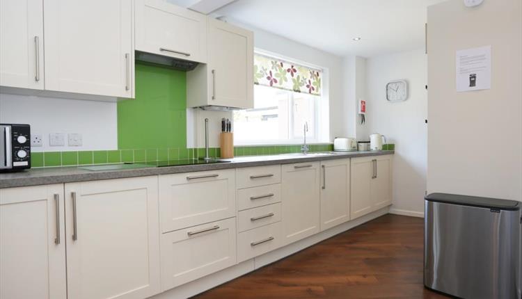 Large white kitchen with a hint of green