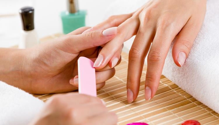 hand getting nails treated at beauty clinic