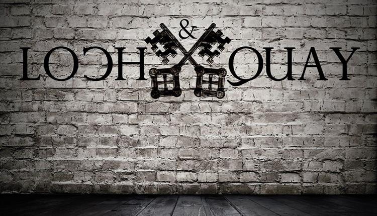loch and quay logo superimposed on a white brick wall.