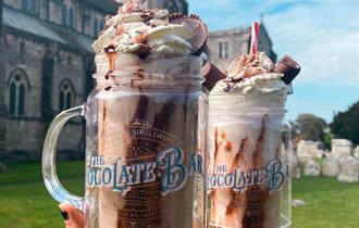 The famous ducking stool milkshakes held in front of the Christchurch priory