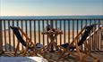 The deck with two deck chairs facing towards the sea