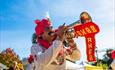 Man dressed in red and white playing a trumpet on a sunny day in Bournemouth