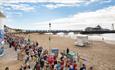 Bournemouth pier on a sunny day with crowds running along the promenade