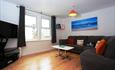 Contrast warm interior with wooden flooring and large flat screen TV