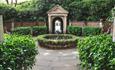 Roman style gardens with water feature in the middle.