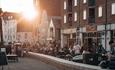 Sun setting over Poole quay with visitors enjoying the bike displays along the seafront