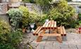 Cosy garden with wooden seating area surrounded with plants and trees