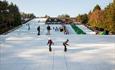 Instructor teaching children how to snowboard on the beginners slope