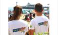 Two people facing the beach with LV Kidzone tshirts