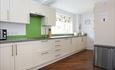 Large white kitchen with a hint of green