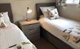 Two beds with sailing boats on the linen and curtains