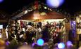 Market stall traders selling goods from their christmas hut