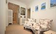 Private hallway with large chairs and paintings on the wall