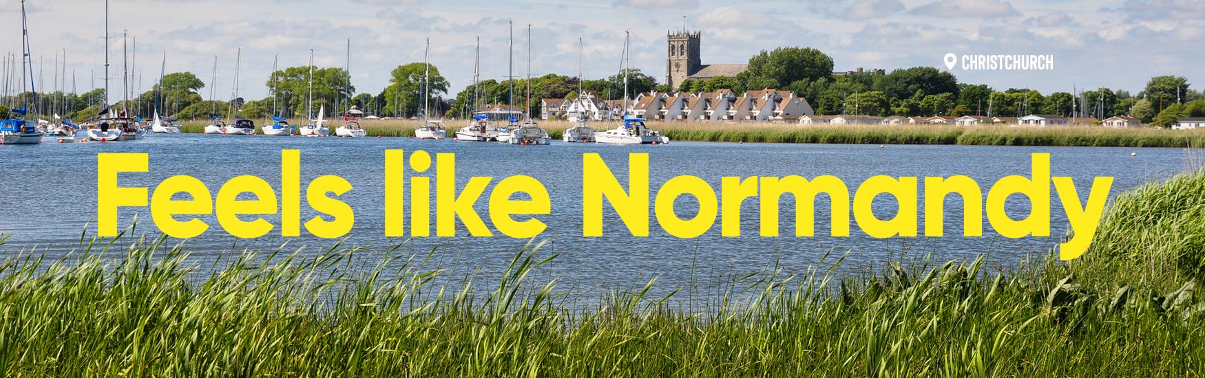 Photo of Christchurch harbour with the priory behind and text overlay that reads feels like normandy