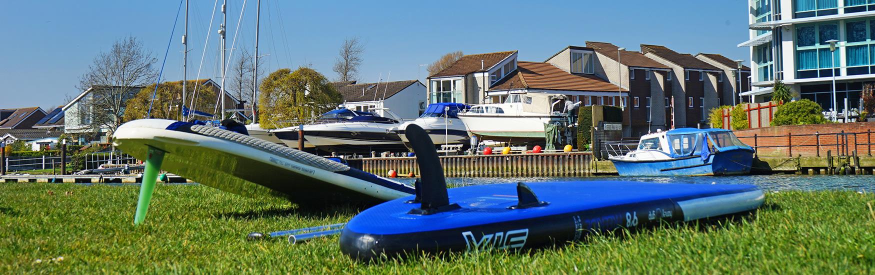 Paddleboards drying out on the grass after a trip out on the Christchurch river