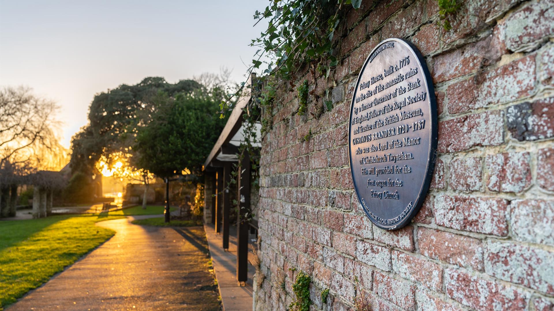 Sunset walk with blue plaque in Christchurch priory gardens