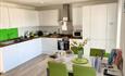 White modern kitchen with table and chairs with lime green highlights