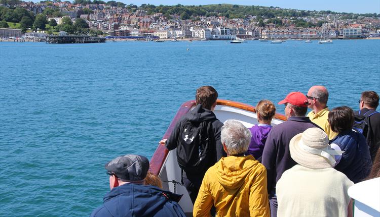 People looking towards the coast on a boat