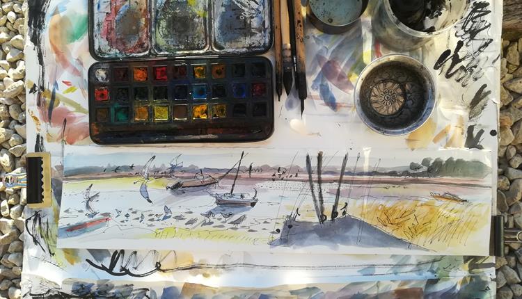 Watercolour pallet outdoors on beach with sketch