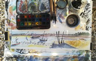 Watercolour pallet outdoors on beach with sketch