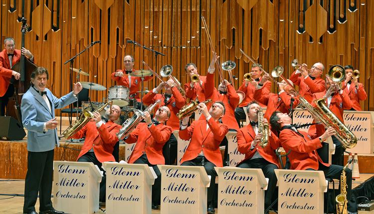 Orchestra players in red clothing playing instruments