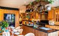 Wooden Kitchen with pots hanging from ceiling