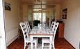 Warm dining area with white decorated table and chairs