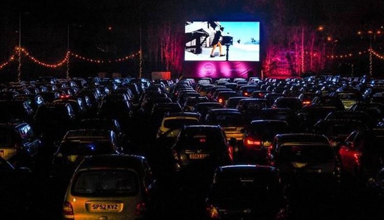 Row of cars looking at a cinema screen