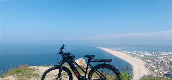 Electronic bike on a cliff overlooking the sea and beach