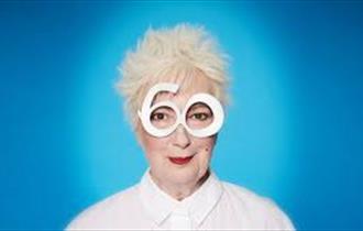 Lady with white hair, white glasses, white shirt and red lipstick