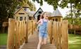 Girl running through wooden play structure