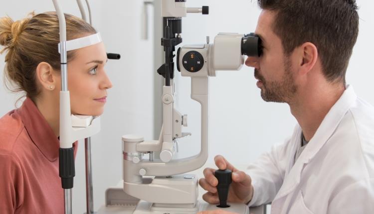 Optician running eye test on patient