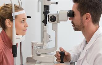Optician running eye test on patient