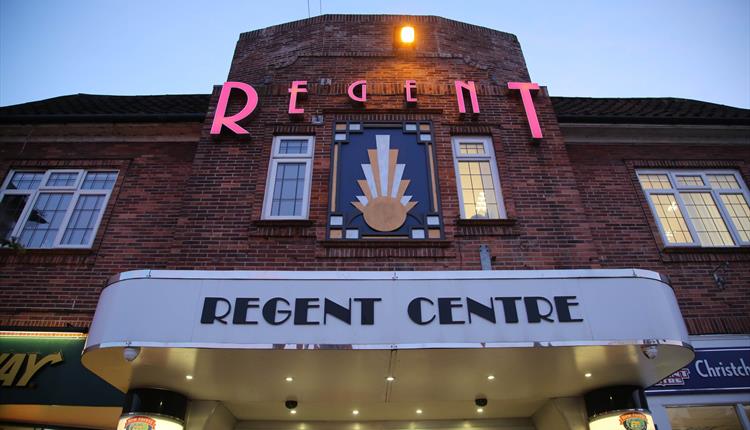 Front of the Regent Centre Building lit up at night time